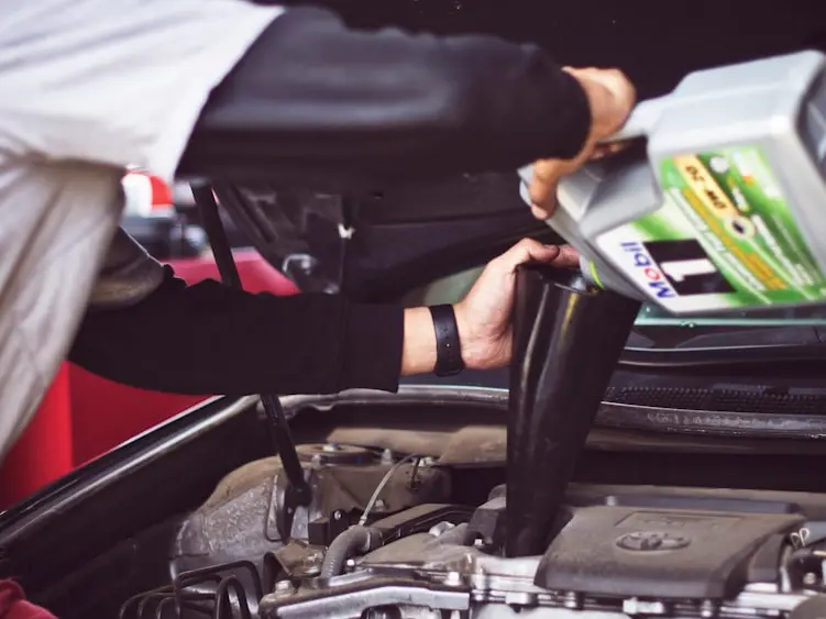 Fluid being added to an engine under an open hood